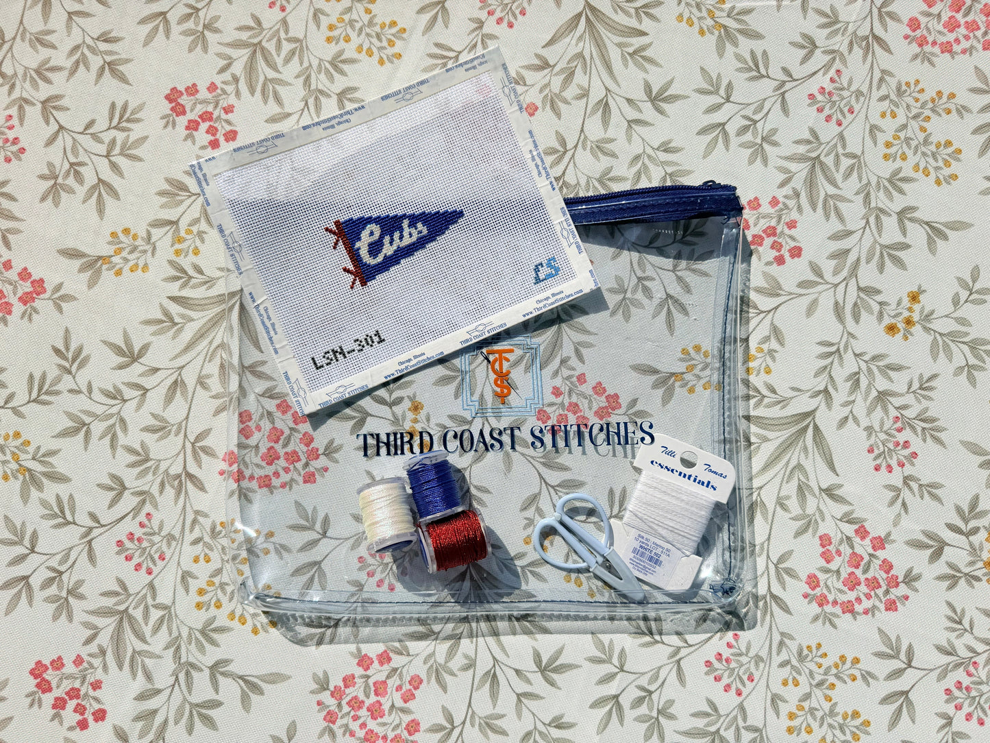 Cubs Pennant canvas and project bag with fibers laying on top of a floral background